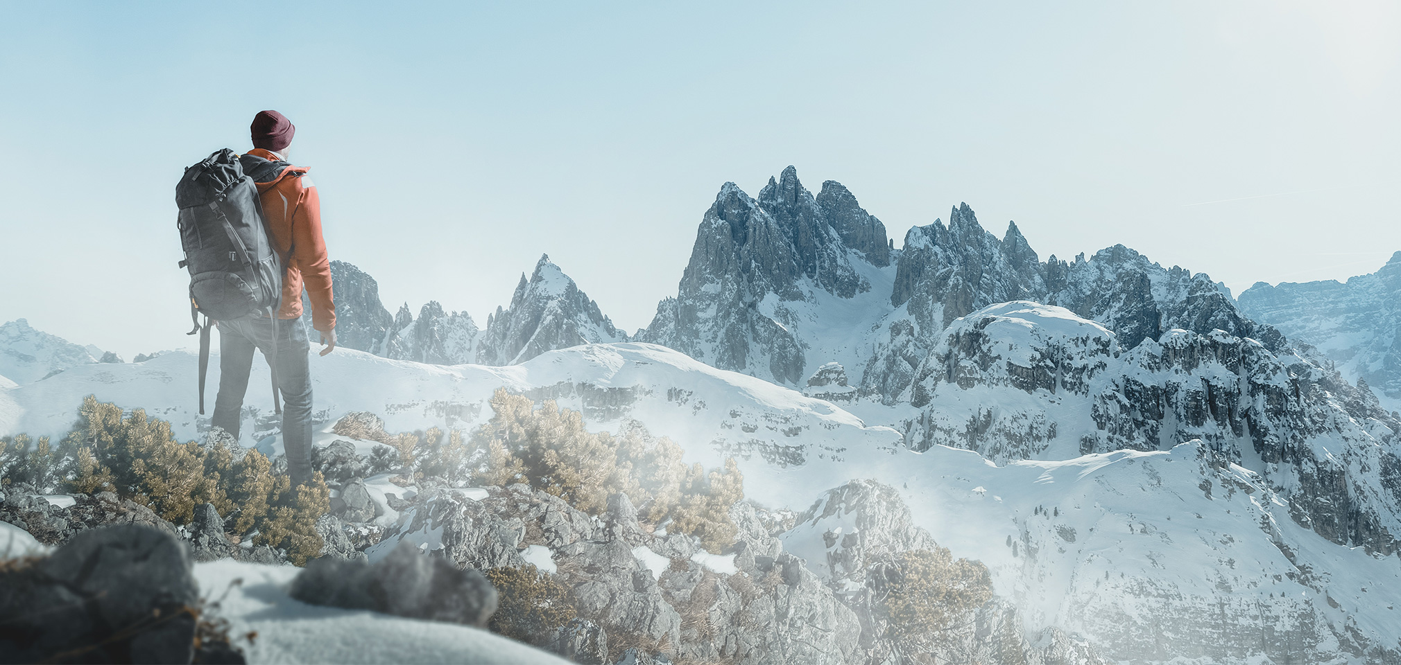 photo d'un homme avec son sac à dos regardant les montagnes enneigées, elle repésente la société CapRol