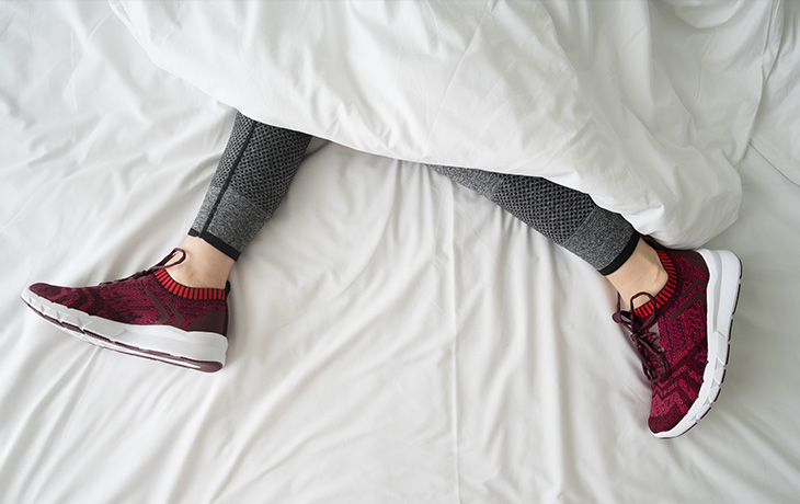 femme en basket dans son lit sous la couette photo pour le Blog santé sport de CapRol
