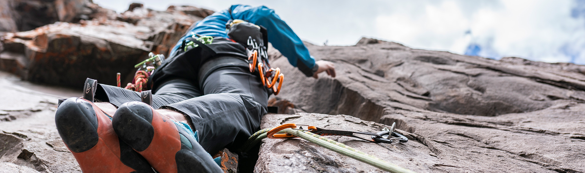 image vue du dessous d'un homme faisant de l'escalade, représentant l'agenda sportif pour les sports individuels dans l'agenda sportif de CapRol